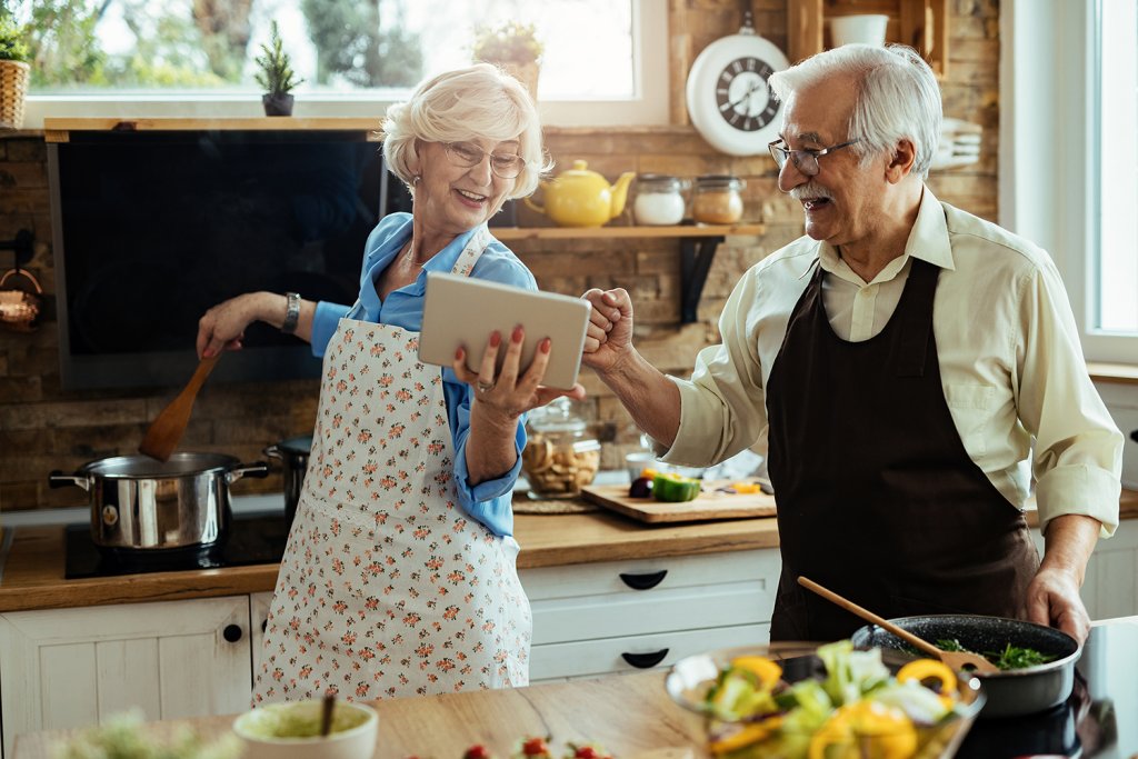 Happy old couple cooking in the kitchen. <a href="https://www.freepik.com/free-photo/cheerful-husband-wife-having-fun-while-preparing-lunch-using-digital-tablet-kitchen_26266078.htm#query=old%20people%20kitchen&position=2&from_view=search&track=ais">Image by Drazen Zigic</a> on Freepik.