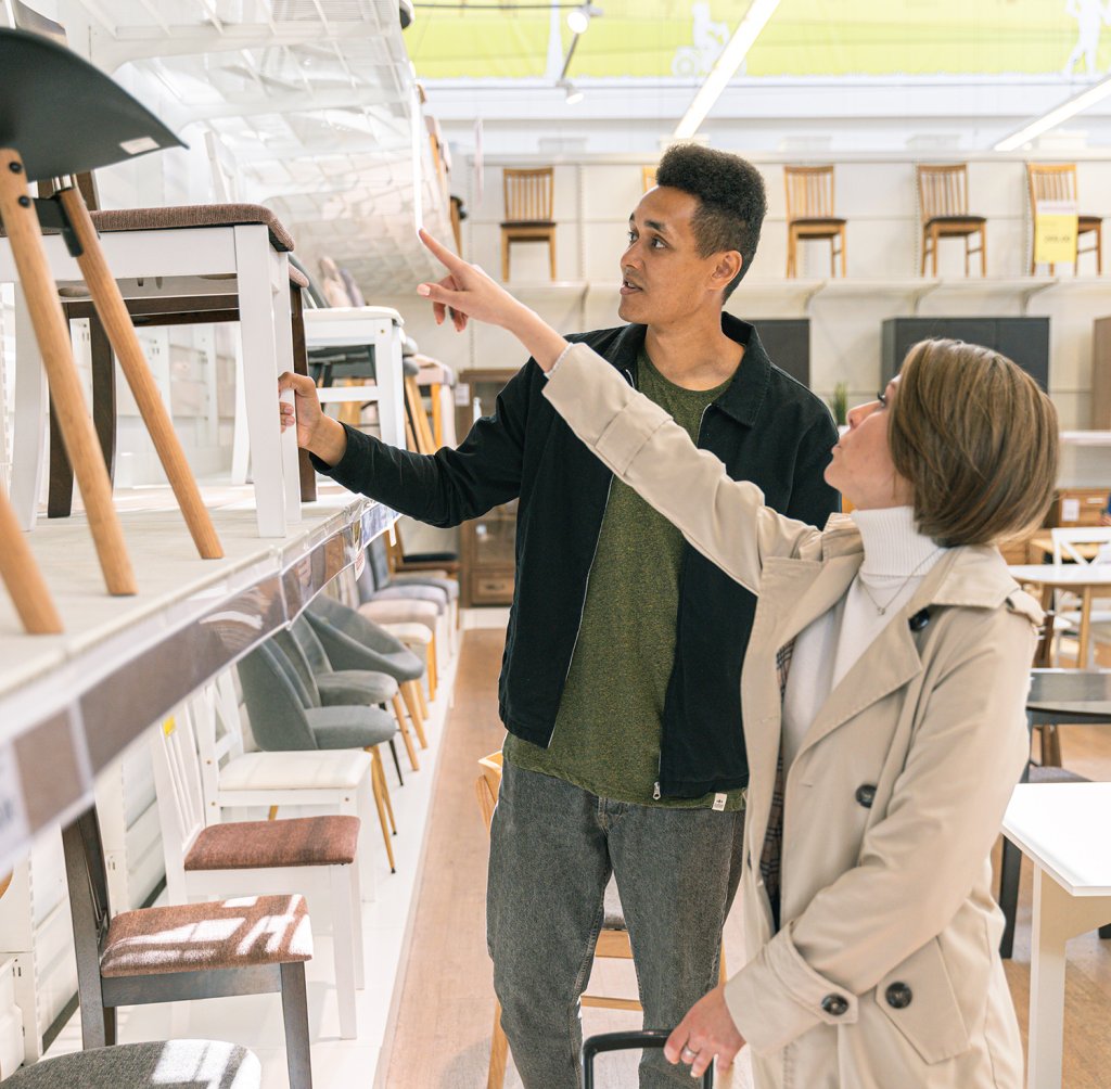 Couple shopping for furniture. Photo by Antoni Shkraba: https://www.pexels.com/photo/man-and-woman-in-furniture-shop-choosing-stools-5486143/.