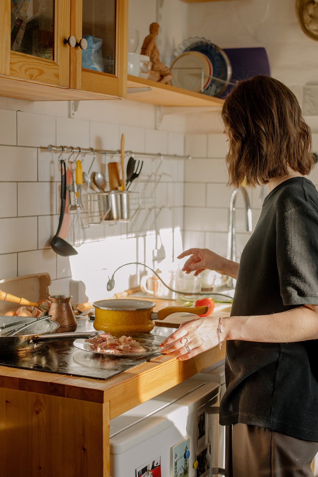Woman cooking on a ceramic hob countertop kitchen. Photo by cottonbro studio: https://www.pexels.com/photo/woman-in-gray-long-sleeve-shirt-standing-in-front-of-kitchen-sink-4781442/.